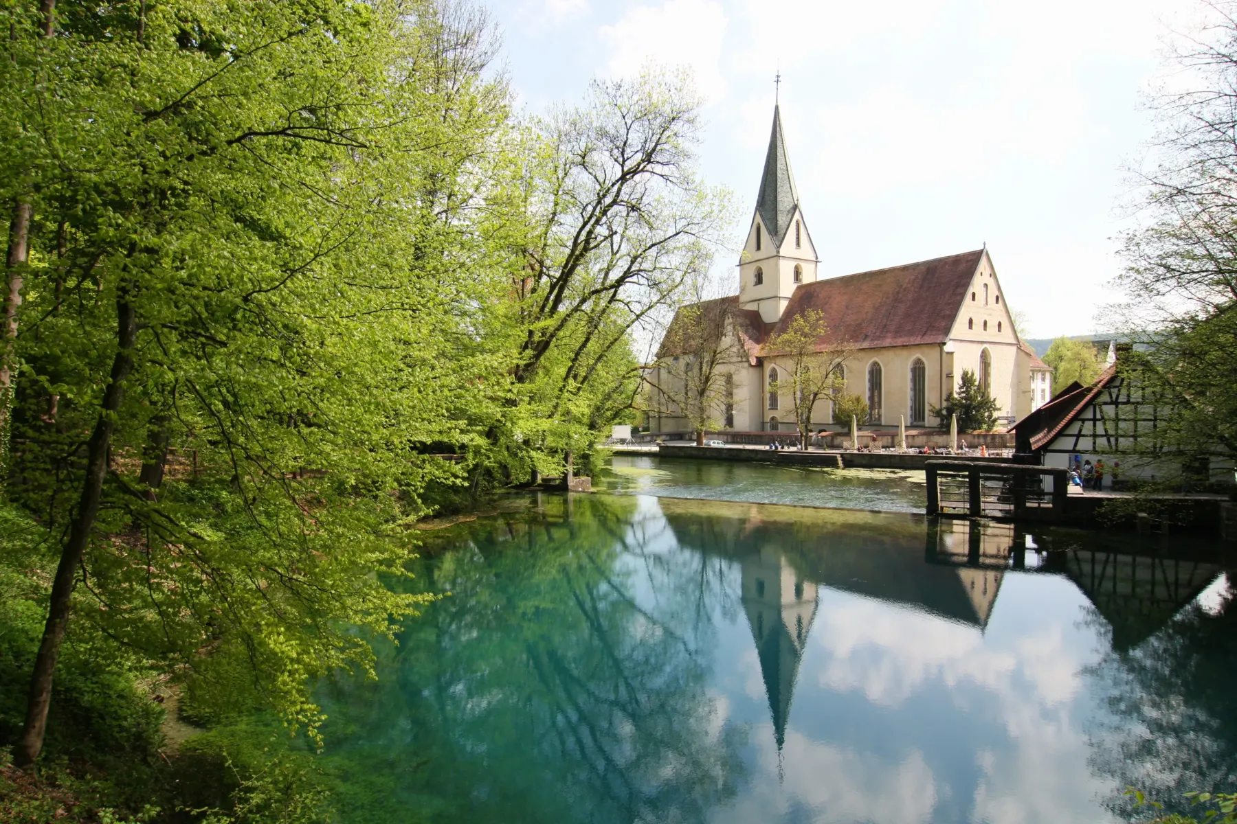 Blautopf mit der Klosterkirche Blaubeuren im Hintergrund.
