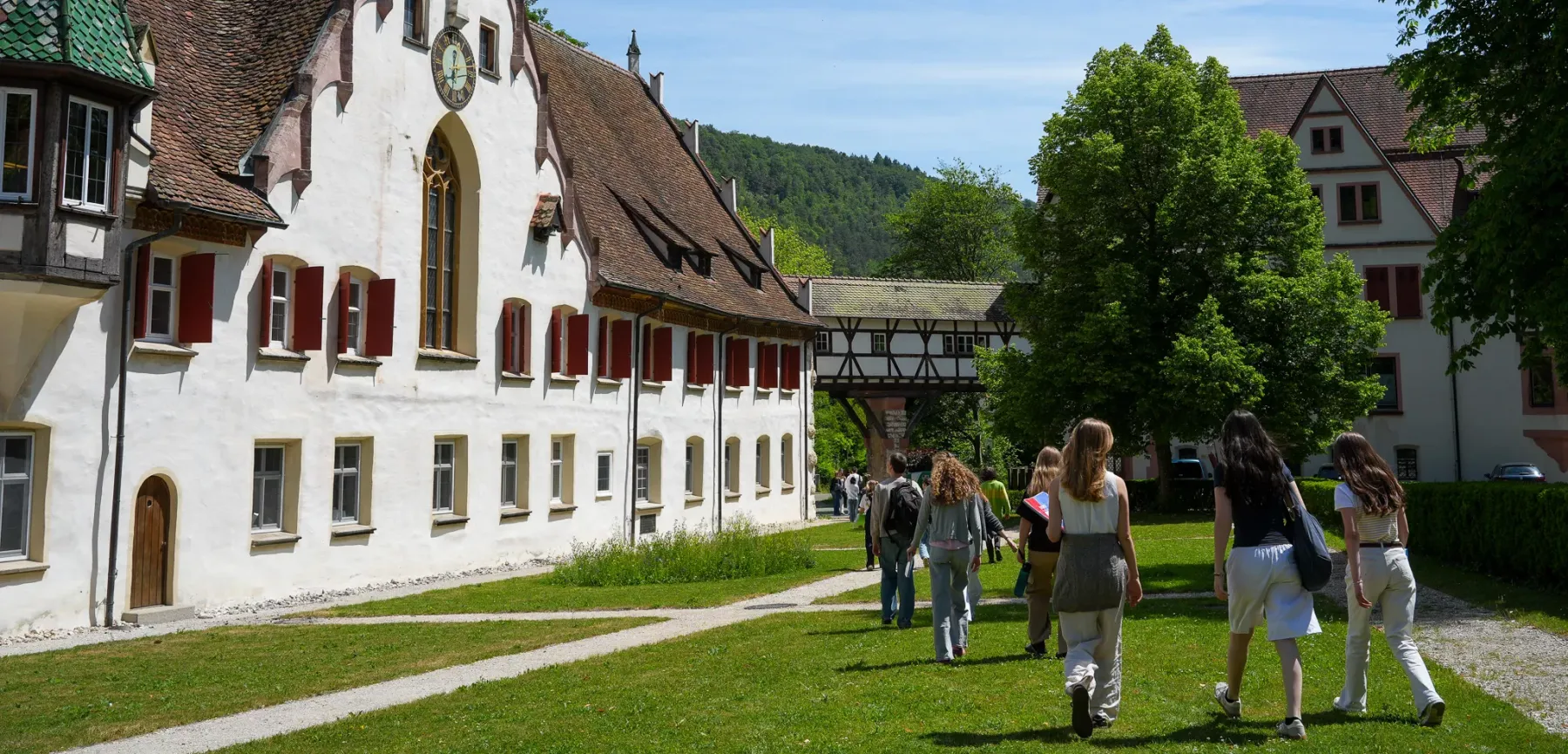 Schülerinnen und Schüler gehen über den Klosterhof auf das ehemalige Kloster zu.